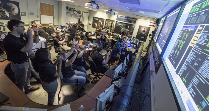 New Horizons Flight Controllers celebrate after they received confirmation from the spacecraft that it had successfully completed the flyby of Pluto, Tuesday, July 14, 2015 in the Mission Operations Center (MOC) of the Johns Hopkins University Applied Physics Laboratory (APL), Laurel, Maryland. Photo Credit: (NASA/Bill Ingalls)